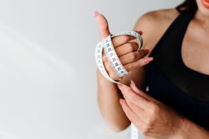 woman holding measuring tape focusing on weight loss